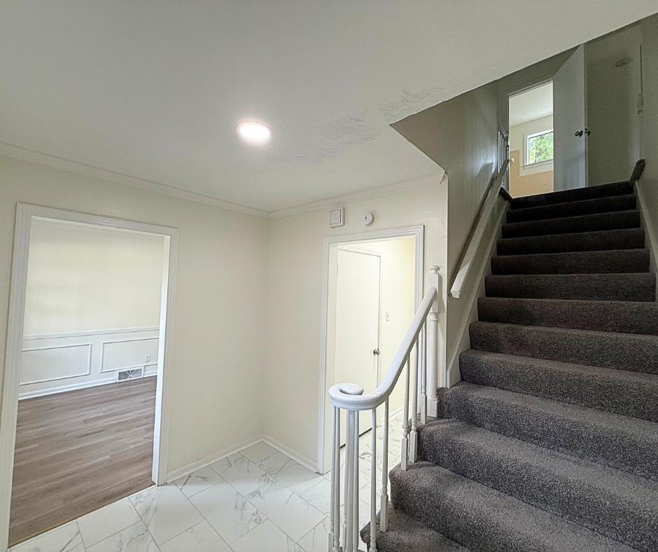 3969 Millbranch Road Memphis, TN 38116 - Photo 4 of 33 Stairs with crown molding, marble look tiles, and recessed lighting
