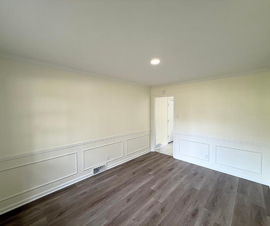 3969 Millbranch Road Memphis, TN 38116 - Photo 5 of 33 Empty room with ornamental molding, recessed lighting, dark wood-style flooring, wainscoting, and a decorative wall