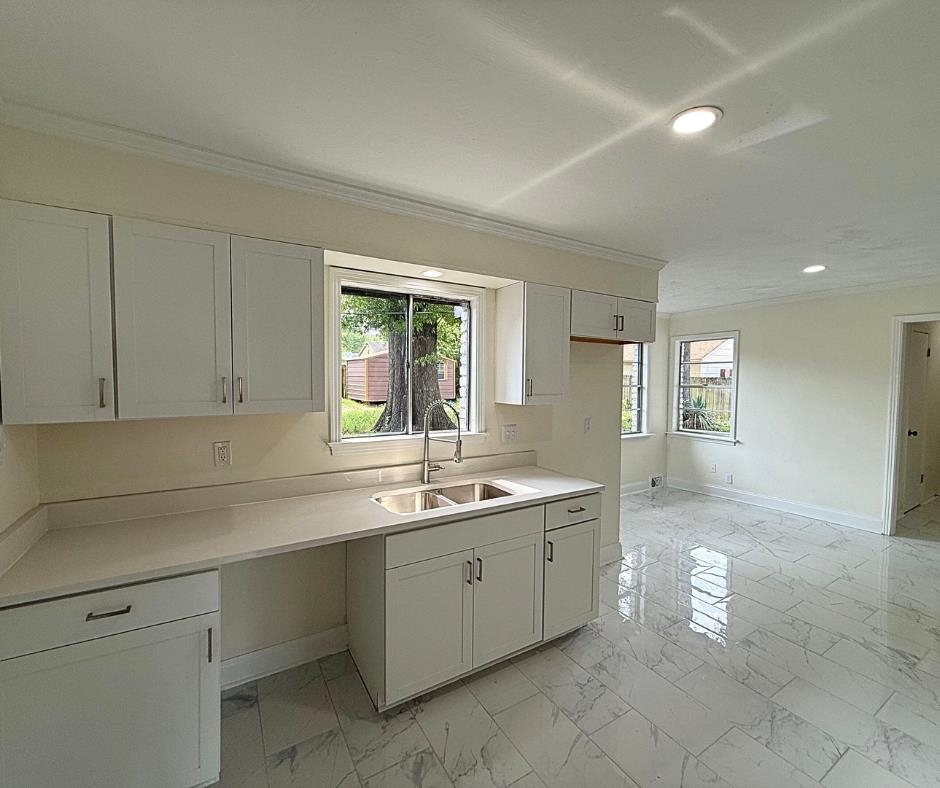 3969 Millbranch Road Memphis, TN 38116 - Photo 9 of 33 Kitchen featuring light marble finish floors, crown molding, recessed lighting, white cabinetry, and light countertops