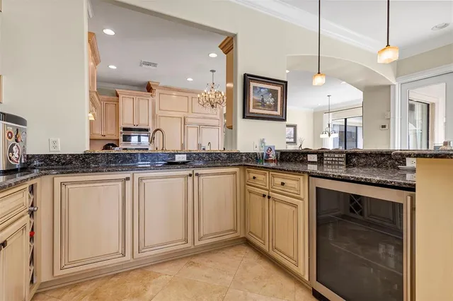 a kitchen with stainless steel appliances kitchen island granite countertop a table chairs in it and wooden floors
