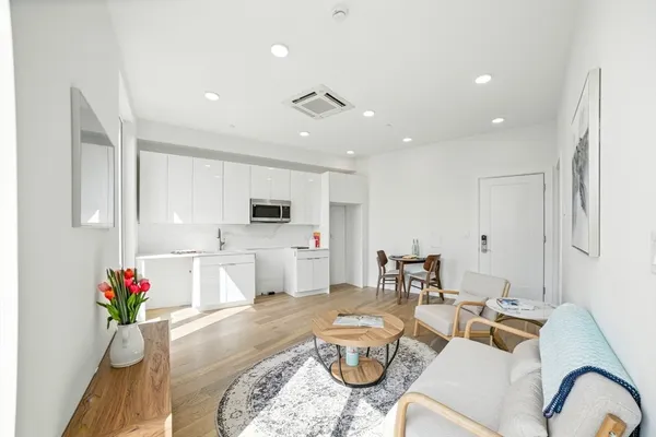 a living room with furniture and kitchen view