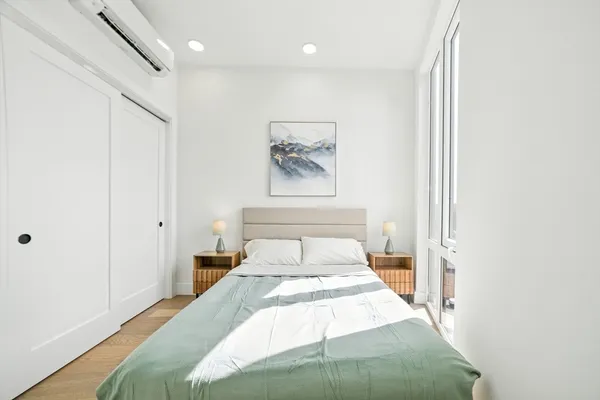 a bedroom with a bed and a painting on the wall