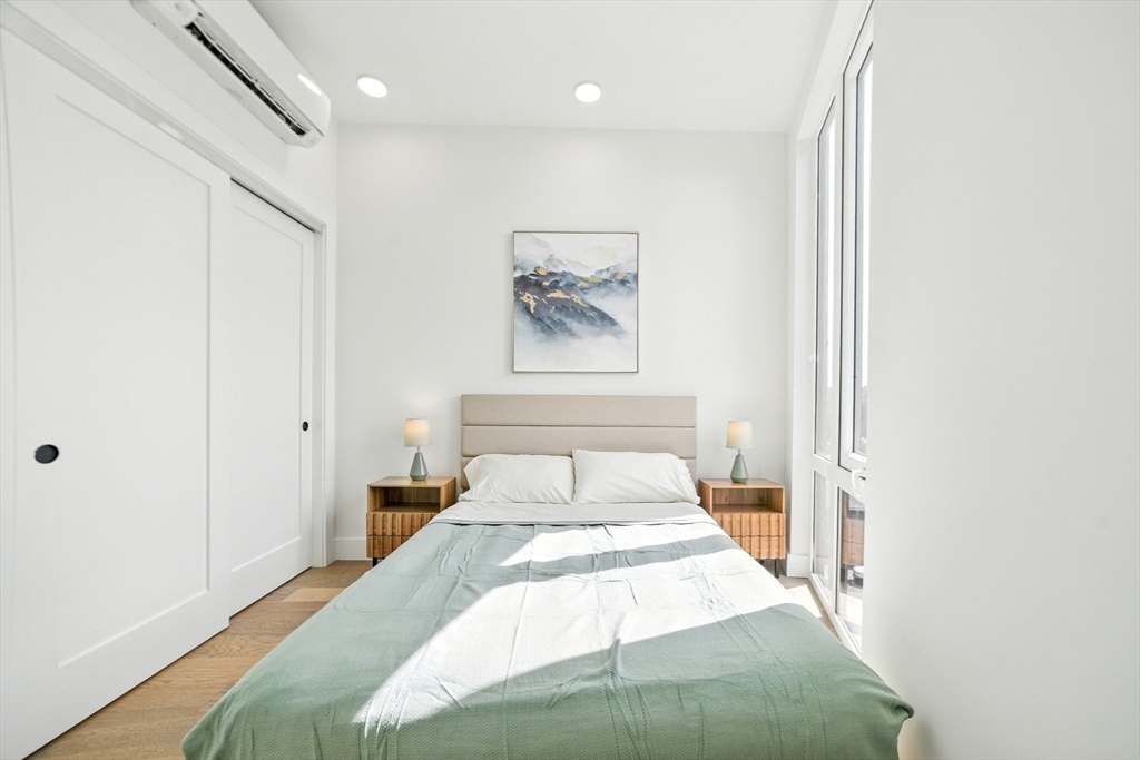 38 Hichborn Street, Unit 505 Boston, MA 02135 - Photo 4 of 9 a bedroom with a bed and a painting on the wall