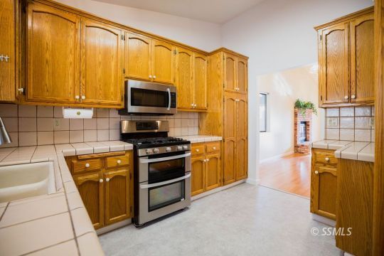 608 Amanda Street Ridgecrest, CA 93555 - Photo 10 of 30 a kitchen with stainless steel appliances granite countertop a refrigerator stove and microwave