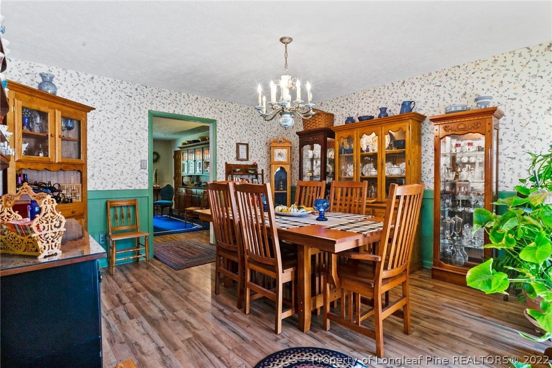 1533 Carl Freeman Road Stedman, NC 28391 - Photo 36 of 48 a view of a dining room with furniture a chandelier and wooden floor