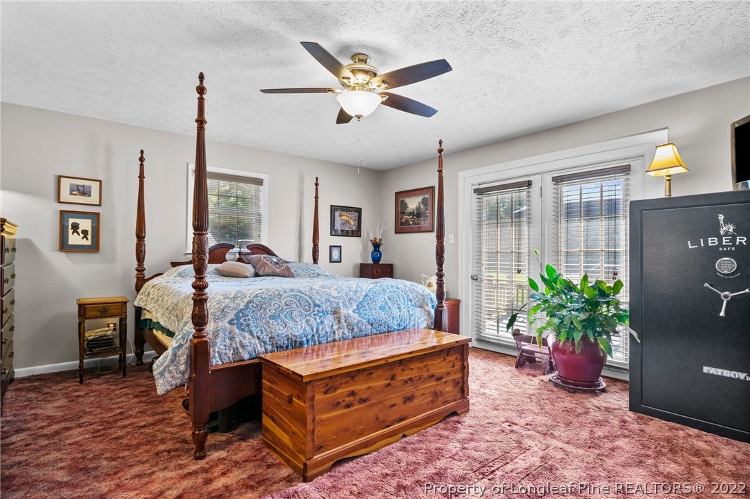 1533 Carl Freeman Road Stedman, NC 28391 - Photo 47 of 48 a bedroom with a bed and a chandelier