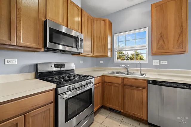 a kitchen with stainless steel appliances granite countertop white cabinets a sink and a stove