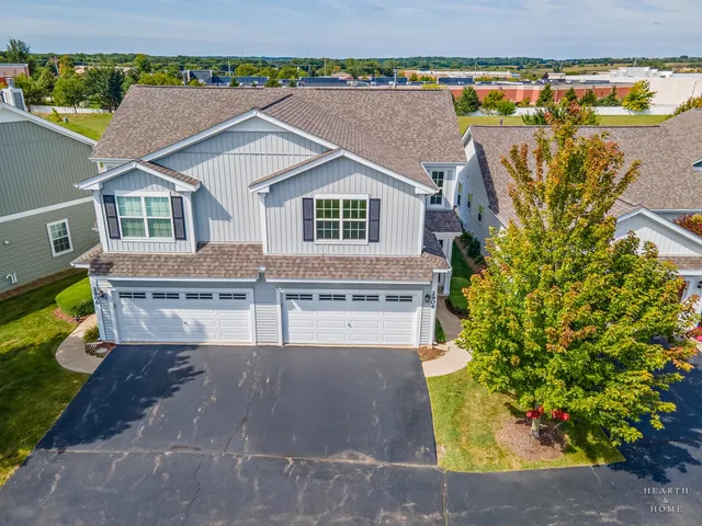 an aerial view of a house with a yard and large tree