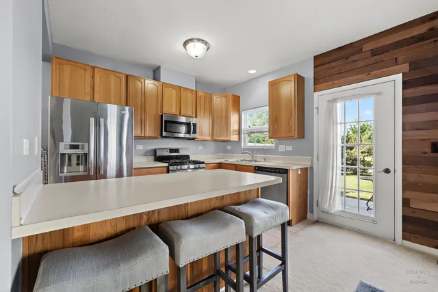 a kitchen with stainless steel appliances a stove a sink refrigerator and a microwave