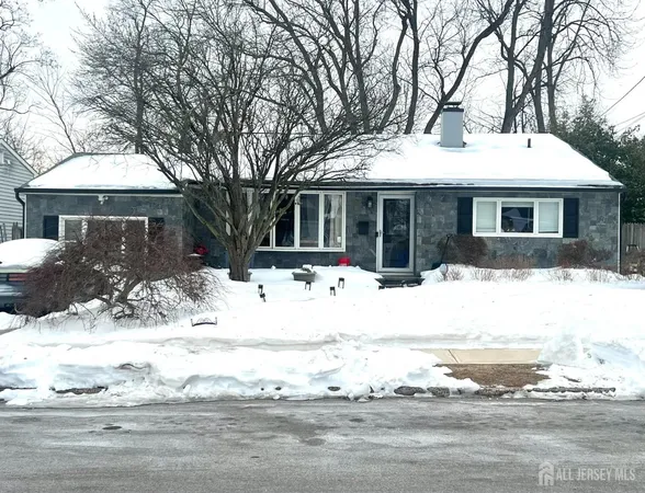 a front view of a house with a yard covered in snow