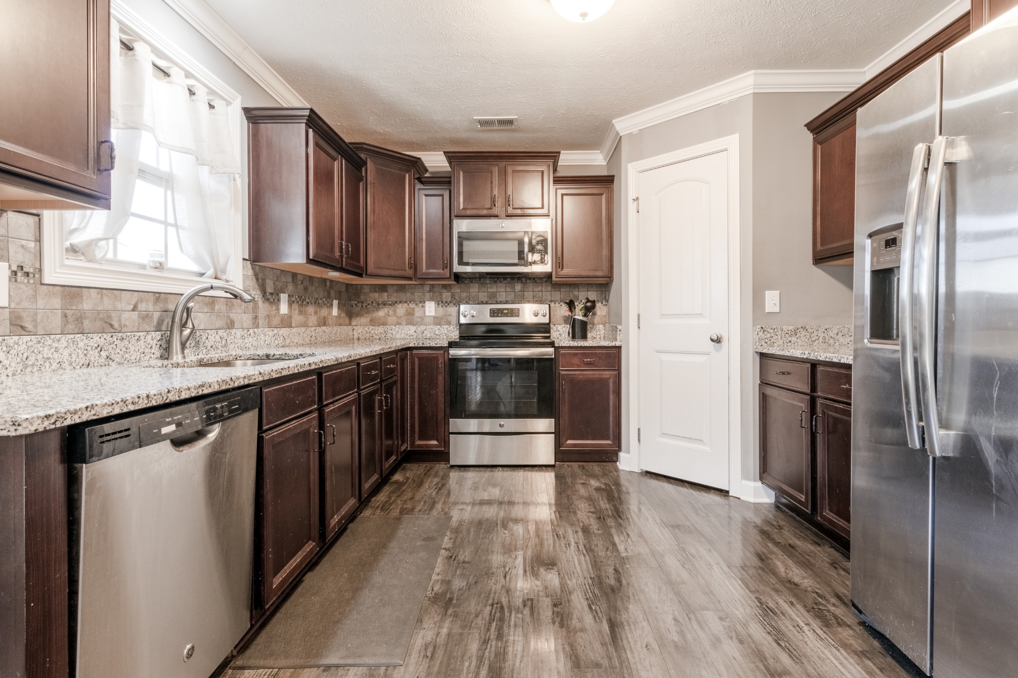 3794 Suiter Road Clarksville, TN 37040 - Photo 11 of 26 a kitchen with stainless steel appliances granite countertop a refrigerator a sink dishwasher a stove with wooden cabinets and floor