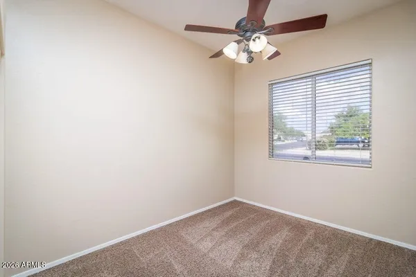 an empty room with a window and a fan