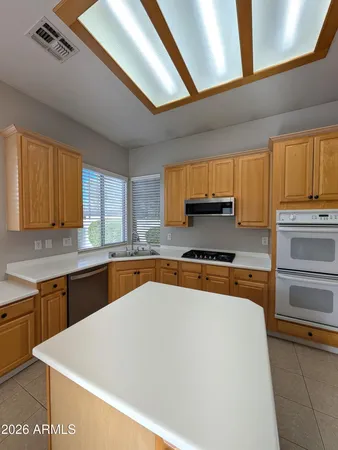 a large kitchen with stainless steel appliances granite countertop a stove a sink and a microwave