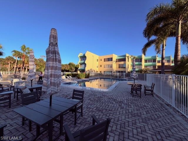 925 Palm View Drive, Unit 121 Naples, FL 34110 - Photo 11 of 13 View of patio / terrace with a community pool and outdoor dining area