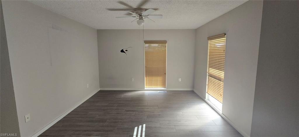 925 Palm View Drive, Unit 121 Naples, FL 34110 - Photo 4 of 13 Unfurnished bedroom with dark wood-style floors, ceiling fan, and a textured ceiling