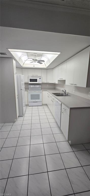925 Palm View Drive, Unit 121 Naples, FL 34110 - Photo 7 of 13 Kitchen featuring white appliances, white cabinetry, light tile patterned floors, and light countertops