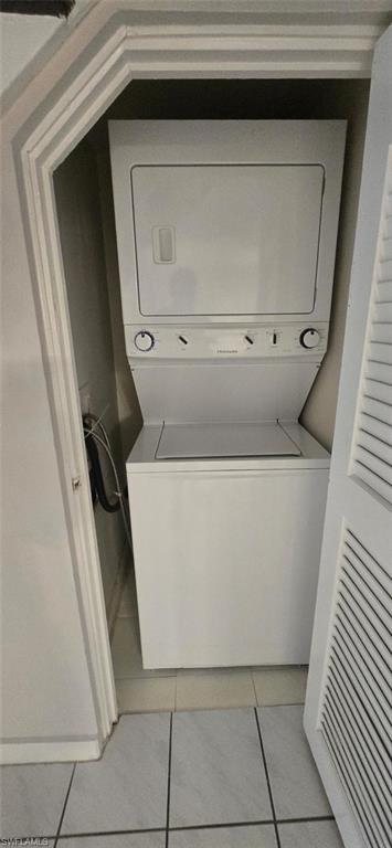 925 Palm View Drive, Unit 121 Naples, FL 34110 - Photo 8 of 13 Laundry area featuring stacked washer / dryer and light tile patterned floors