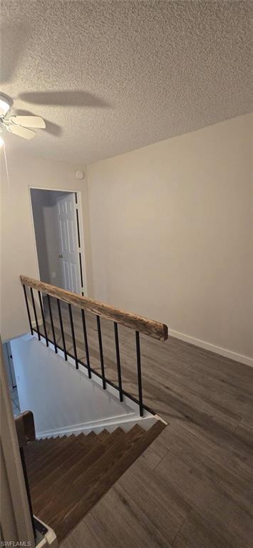 925 Palm View Drive, Unit 121 Naples, FL 34110 - Photo 10 of 13 Stairway featuring wood finished floors, a textured ceiling, and ceiling fan
