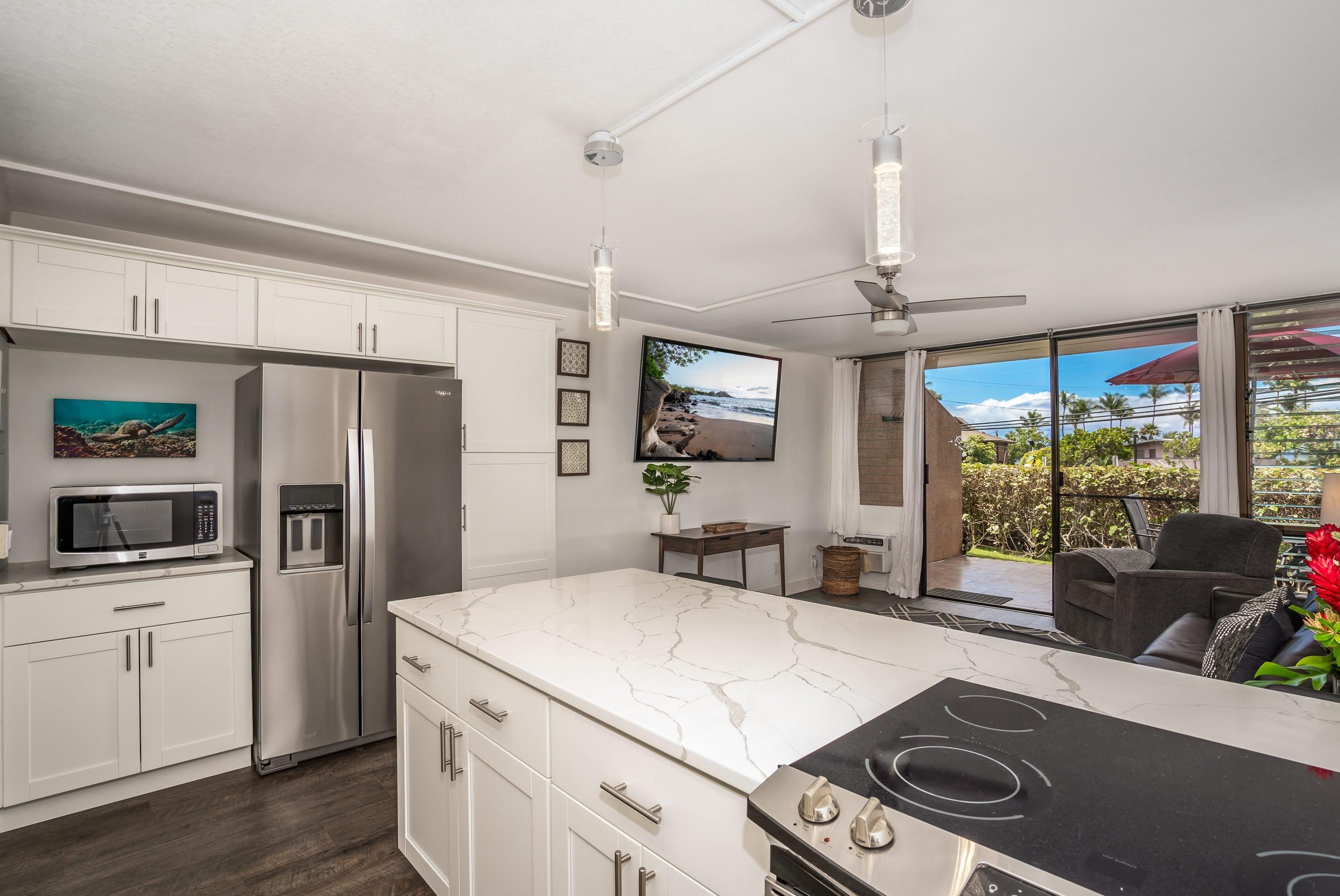 2191 South Kihei Road, Unit 1118 Kihei, HI 96753 - Photo 3 of 40 a kitchen with a sink stainless steel appliances a large window and cabinets