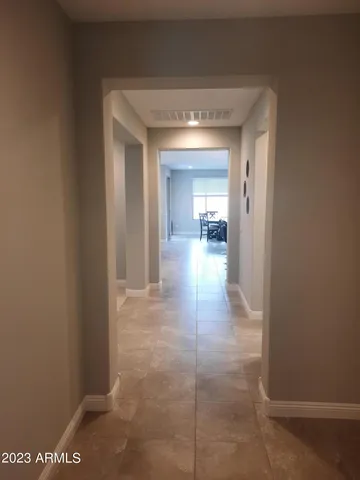 a view of a hallway with a glass door and a window