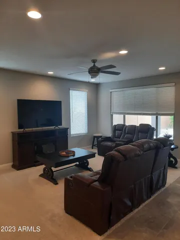 a living room with furniture a flat screen tv and gym equipment