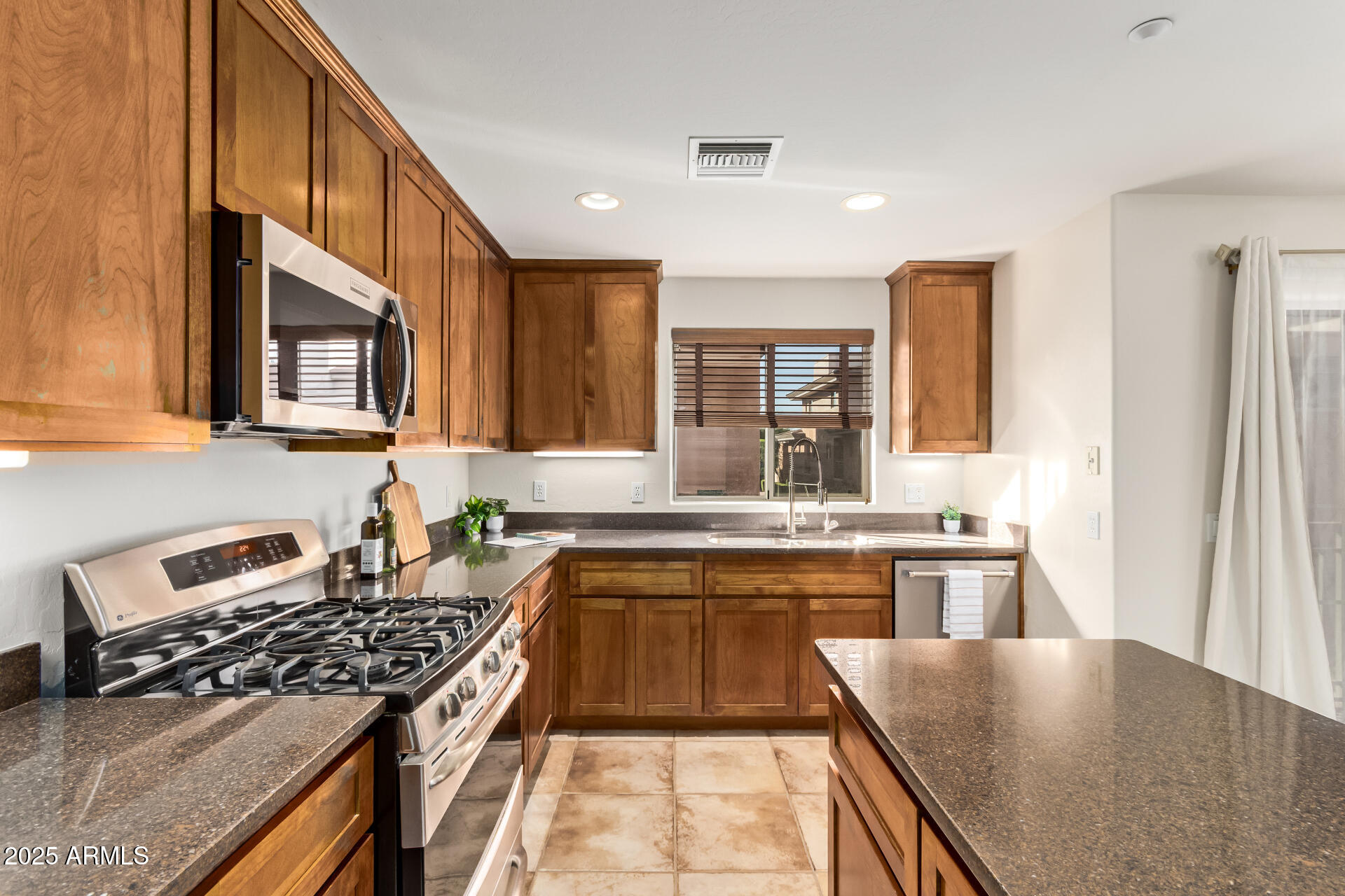 6940 East Cochise Road, Unit 1016 Paradise Valley, AZ 85253 - Photo 6 of 39 a kitchen with a stove a sink and a refrigerator