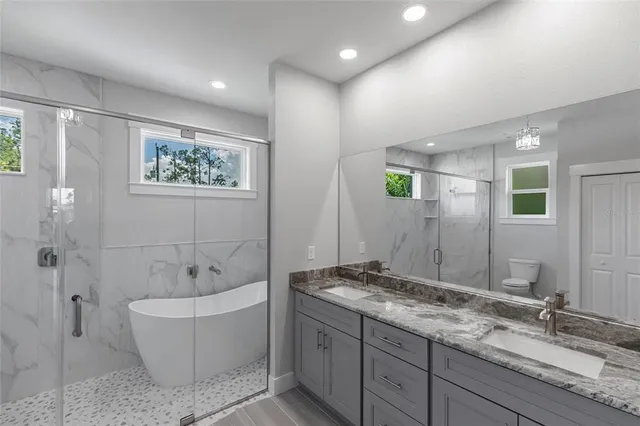 a bathroom with a granite countertop sink a toilet and shower