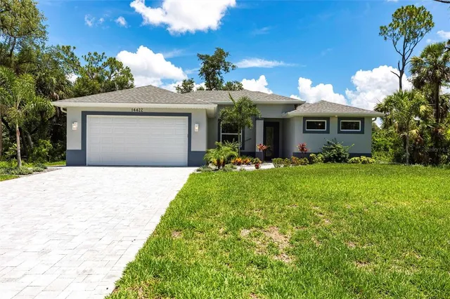 a front view of a house with a yard and a garage
