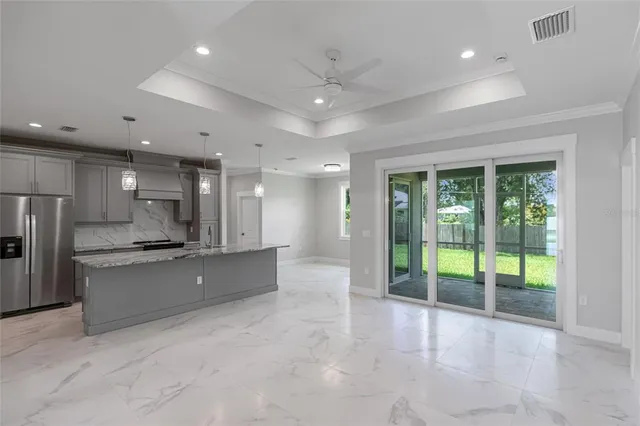 a kitchen with kitchen island granite countertop a refrigerator a sink and a stove