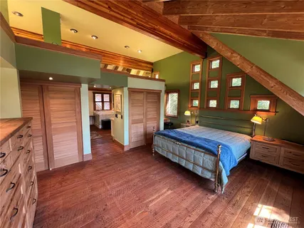 a bedroom with a bed and dresser with mirror