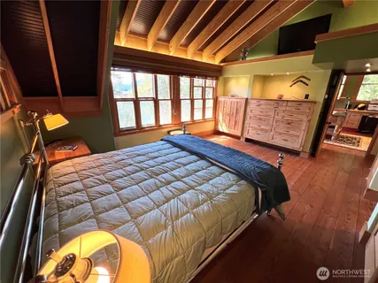 a bedroom with a bed and wooden floor