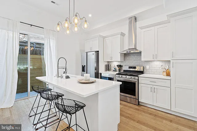 a kitchen with a stove a sink a dining table and chairs