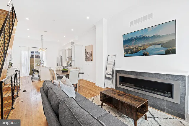a living room with furniture a flat screen tv and a fireplace