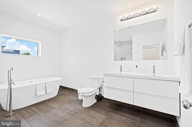 a bathroom with a toilet a sink and mirror