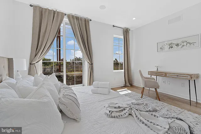 a bedroom with a bed and a large window