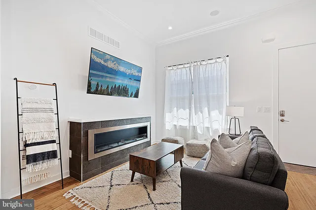 a living room with furniture a fireplace and a floor to ceiling window
