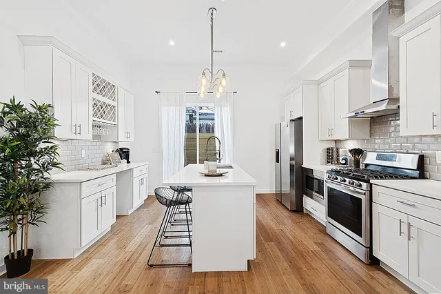 a large kitchen with a white stove top oven and white cabinets