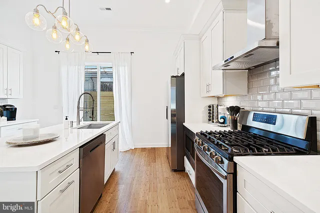 a kitchen with granite countertop a sink stove and cabinets