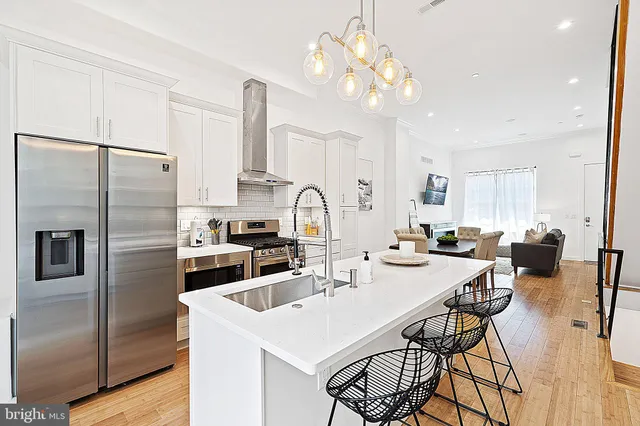 a kitchen that has a lot of cabinets a sink and appliances
