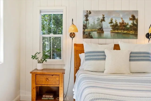 a bedroom with a bed and a painting on the wall