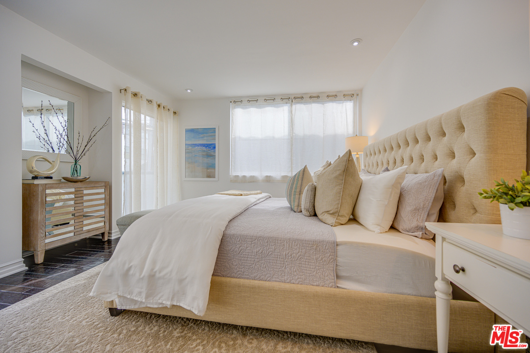 a bedroom with a bed and a tv on the dresser