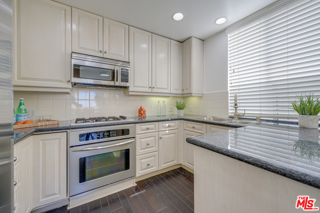 4 Quarterdeck Street, Unit 101 Marina del Rey, CA 90292 - Photo 20 of 29 a kitchen with stainless steel appliances granite countertop a sink a stove and cabinets