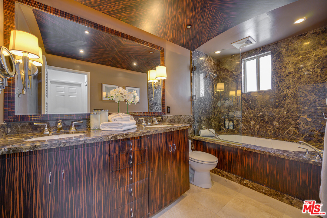 4 Quarterdeck Street, Unit 101 Marina del Rey, CA 90292 - Photo 4 of 29 a bathroom with a granite countertop sink a toilet a mirror and bathtub