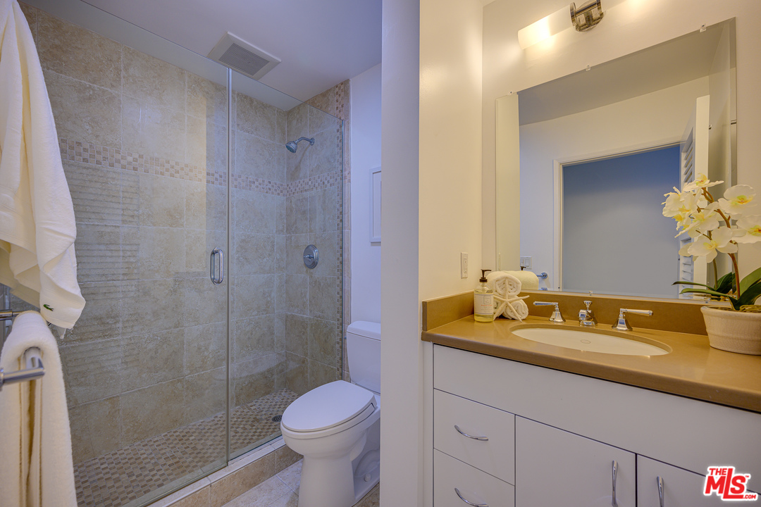4 Quarterdeck Street, Unit 101 Marina del Rey, CA 90292 - Photo 9 of 29 a bathroom with a granite countertop sink a toilet and a mirror