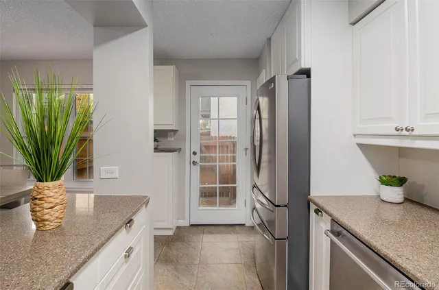 a kitchen with stainless steel appliances granite countertop a potted plant on the counter