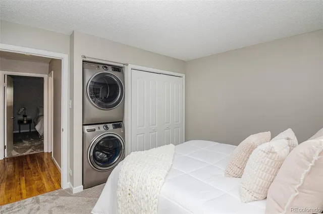 a bedroom with a bed and a washing machine in it