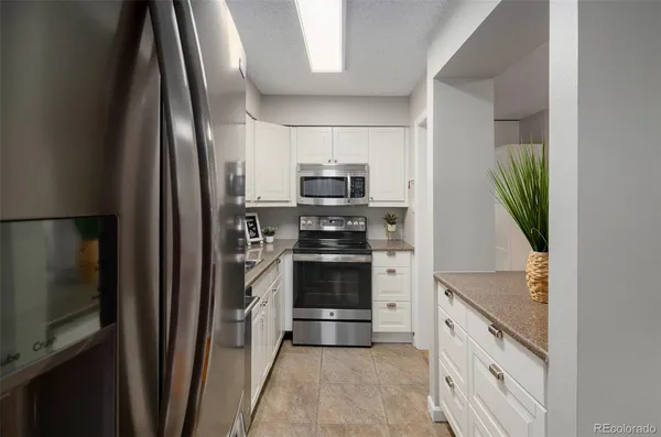 a kitchen with white cabinets and stainless steel appliances