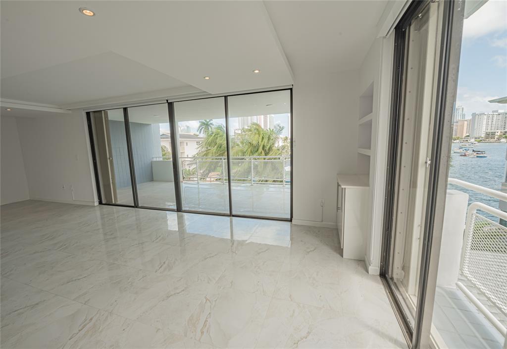468 Golden Isles Drive, Unit 402 Hallandale Beach, FL 33009 - Photo 16 of 53 a view of an empty room with a sliding door