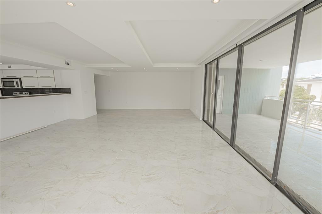 468 Golden Isles Drive, Unit 402 Hallandale Beach, FL 33009 - Photo 20 of 53 a view of a refrigerator in kitchen and an empty room