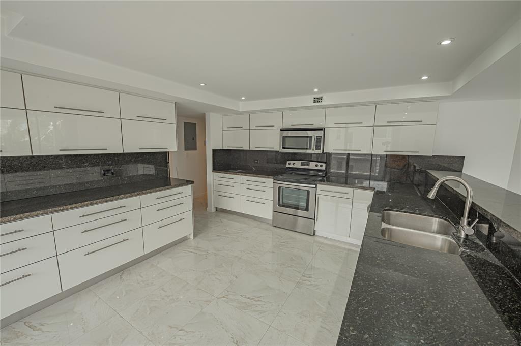 468 Golden Isles Drive, Unit 402 Hallandale Beach, FL 33009 - Photo 24 of 53 a kitchen with stainless steel appliances granite countertop a stove a sink and a refrigerator